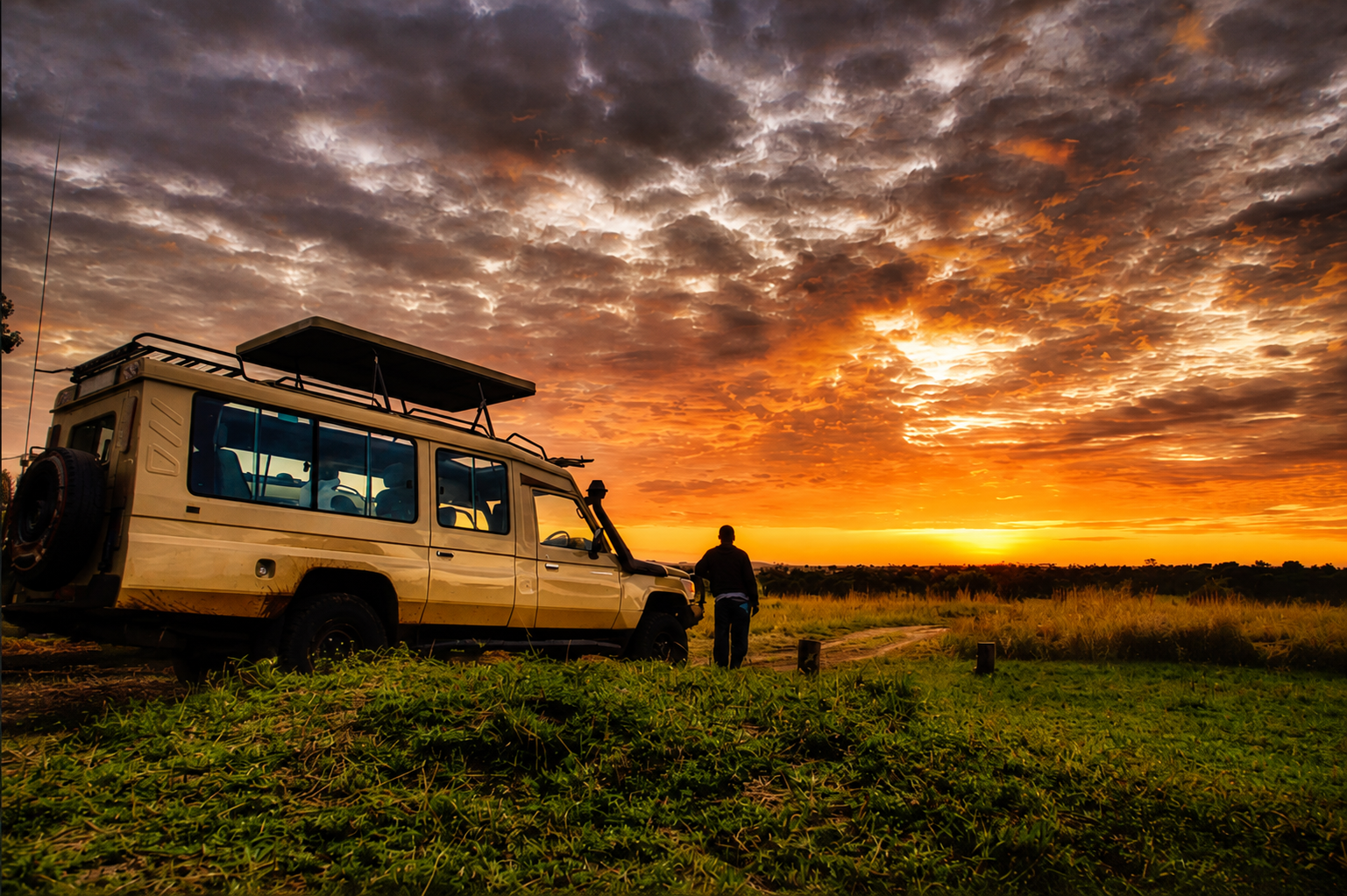 Safari vehicle and guide at golden sunset on the Tanzanian savanna